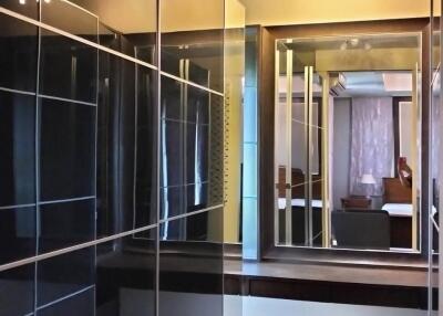 Walk-in closet with mirrored sliding doors and wooden flooring