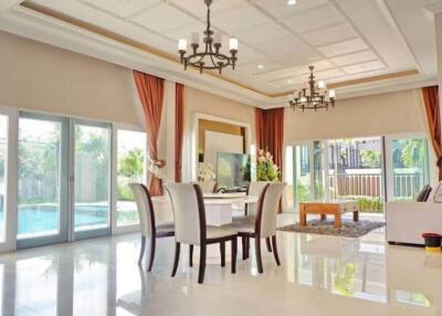 Spacious living room with large windows, stylish ceiling fixtures, and pool view