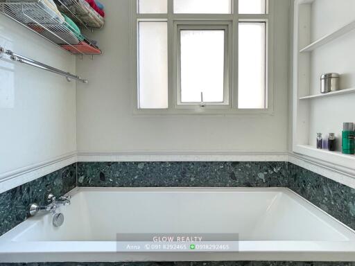 Bathroom with bathtub, window, and shelving