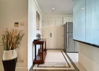 Entryway with a console table, decorative plant, and view of the kitchen and refrigerator