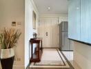 Entryway with a console table, decorative plant, and view of the kitchen and refrigerator