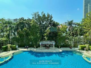 Swimming pool area with pergola and surrounding greenery