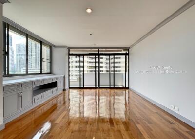 Spacious living room with large windows and polished wooden floors