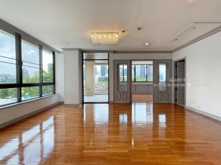 Spacious living room with large windows and hardwood floors