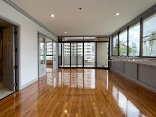 Spacious living room with large windows and wooden flooring