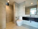 Modern bathroom with toilet, shower, large mirror, and sleek vanity