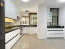 Modern kitchen with white cabinets and black countertops