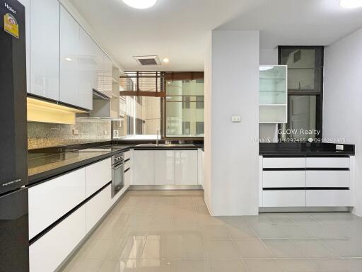 Modern kitchen with white cabinets and black countertops