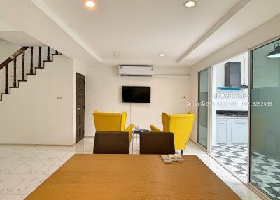 Modern living room with yellow chairs and a wall-mounted TV