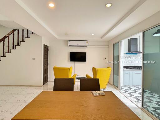 Modern living room with yellow chairs and a wall-mounted TV