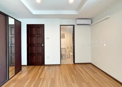 Spacious modern bedroom with wooden floor, built-in wardrobe, and en-suite bathroom