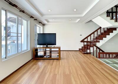 Spacious living room with large windows and wooden flooring