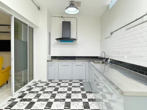 Modern kitchen with checkered floor, white tile backsplash, and stainless steel sink