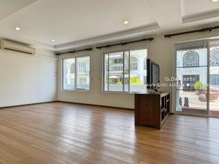 Spacious living room with wooden flooring and large windows