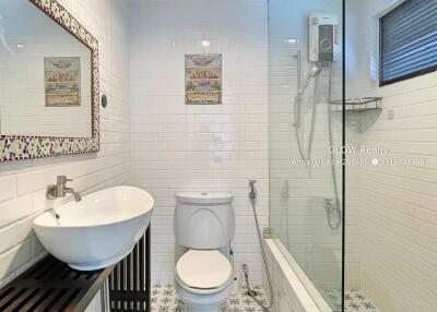 Clean and modern bathroom with white tiles, shower area, and vanity sink