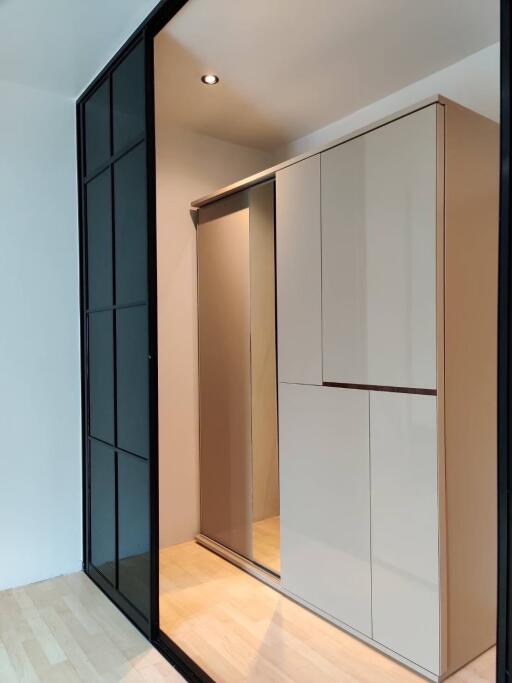 Modern bedroom with sleek wardrobe and black framed glass partition