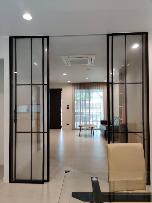 Modern living space with glass partitions and ceiling lights