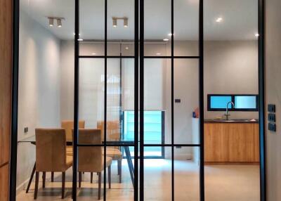 Modern dining room with glass partition and view into kitchen