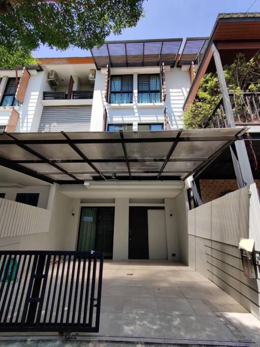 Exterior view of a modern multi-story house with carport