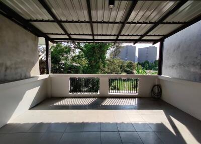 Spacious balcony with a metal roof and open view