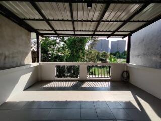 Spacious balcony with a metal roof and open view