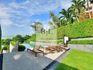 Poolside area with lounge chairs and lush greenery