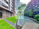 Outdoor landscape with green lawn, modern building, and water feature