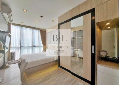 Modern bedroom with a large bed, wardrobe, and study desk