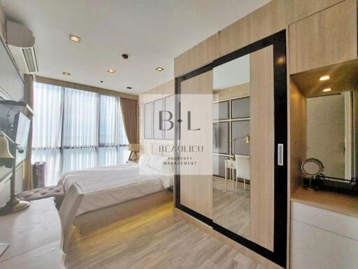 Modern bedroom with a large bed, wardrobe, and study desk