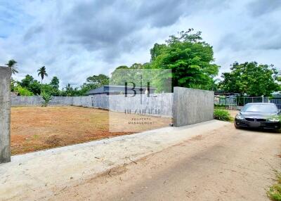 View of property with driveway and surrounding vegetation