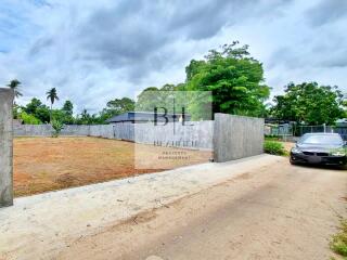 View of property with driveway and surrounding vegetation