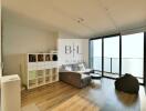 Modern living room with large windows and bookshelf