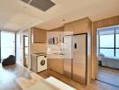 Modern apartment unit with a fully equipped kitchen and a view into the bedroom