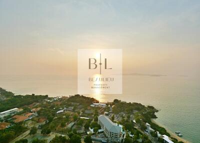 Aerial view of coastal area at sunset with seaside residential buildings