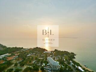 Aerial view of coastal area at sunset with seaside residential buildings