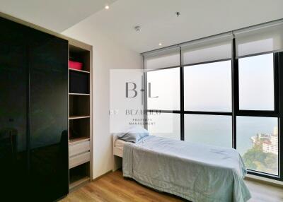 Modern bedroom with large floor-to-ceiling windows and a wardrobe