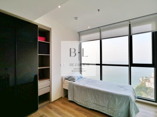 Modern bedroom with large floor-to-ceiling windows and a wardrobe