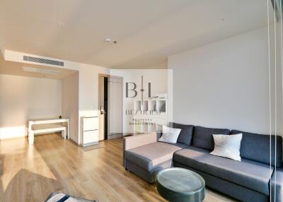 Modern living room with wooden flooring, gray sofa, and minimalist decor