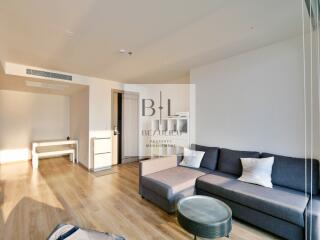 Modern living room with wooden flooring, gray sofa, and minimalist decor