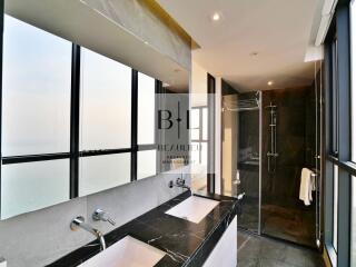 Modern bathroom with dual sinks and a walk-in shower