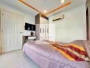 Modern bedroom with bed, wall-mounted TV, air conditioner, and wardrobe