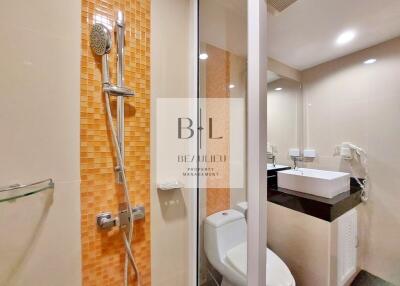Modern bathroom with orange mosaic tiling and glass shower door
