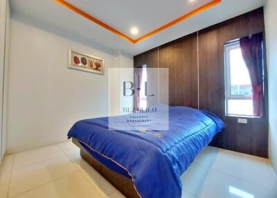 Modern bedroom with blue bedspread and recessed ceiling lighting