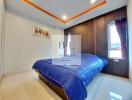 Modern bedroom with blue bedspread and recessed ceiling lighting