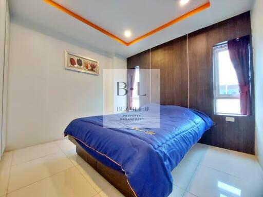 Modern bedroom with blue bedspread and recessed ceiling lighting