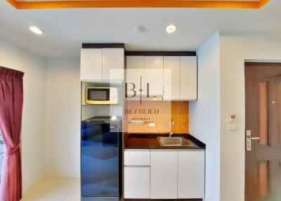 Small modern kitchen with white cabinets, black appliances, and a sink