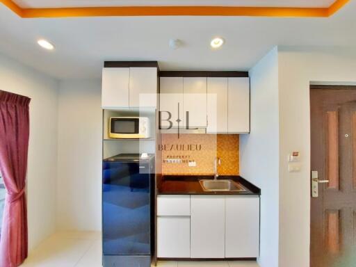 Small modern kitchen with white cabinets, black appliances, and a sink