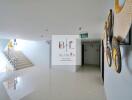 Bright and clean building hallway with decorative wall art and an emergency exit sign