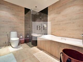 Modern bathroom with a glass-enclosed shower, bathtub, and toilet