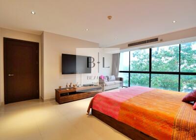 Spacious and well-lit bedroom with large windows and modern furnishings